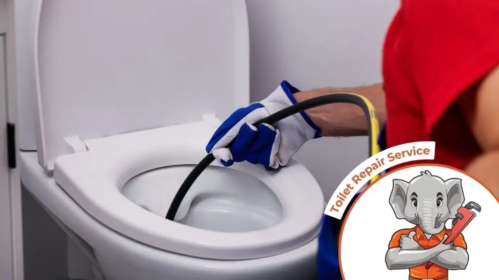 plumber unclogging blocked toilet with hydro jetting at home bathroom