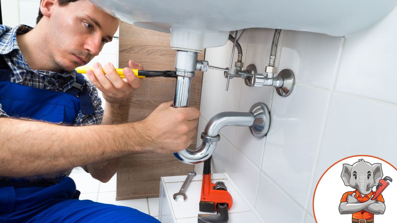 Plumber fixing sink pipes in a bathroom